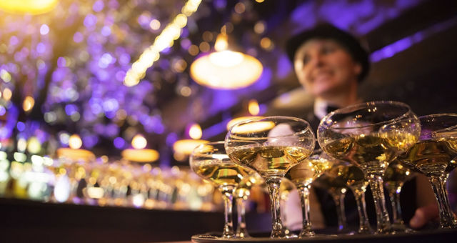 happy waitress holding a tray full of glasses or welcome drinks