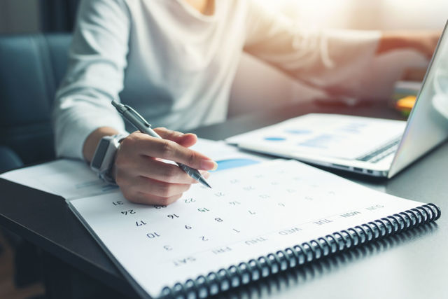 Business woman sitting working and thinking to plan event with c