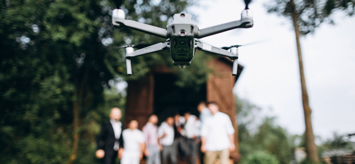 A drone in the air shoots a group of people at a party in the op