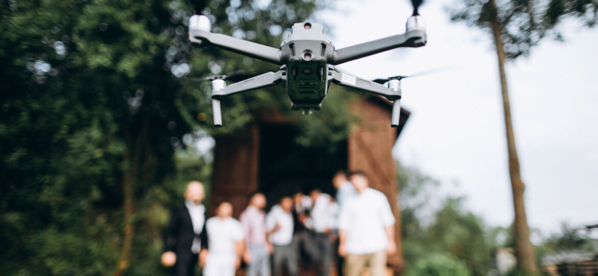 A drone in the air shoots a group of people at a party in the op