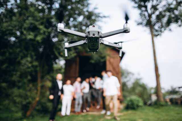 A drone in the air shoots a group of people at a party in the op