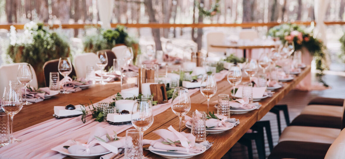 wooden banquet tables decorated with floral arrangements, on the