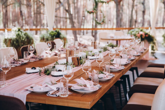 wooden banquet tables decorated with floral arrangements, on the