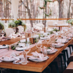 wooden banquet tables decorated with floral arrangements, on the