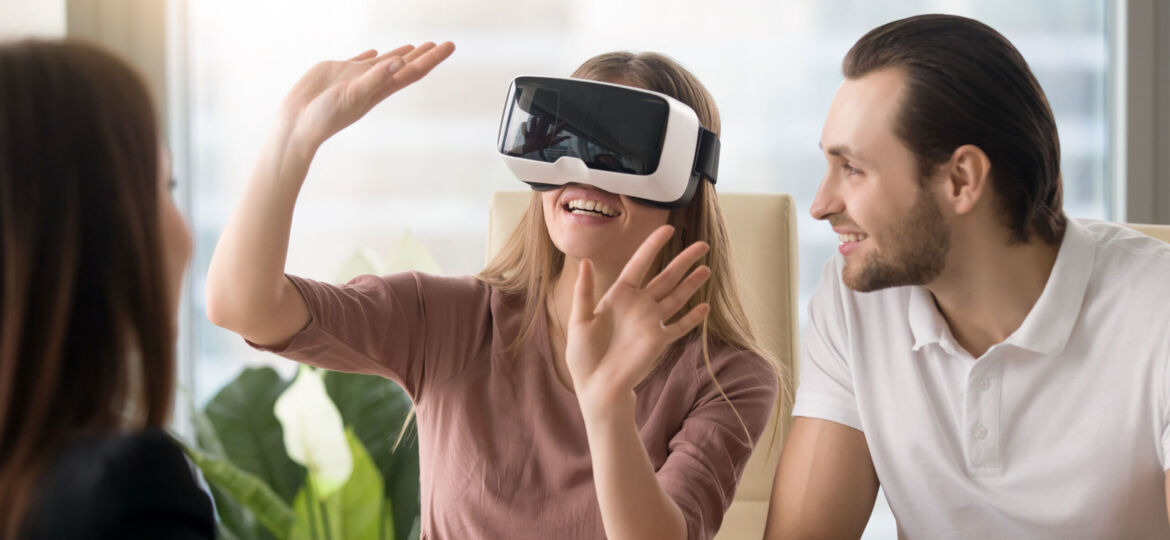 Woman wearing virtual reality headset, team developing VR glasse