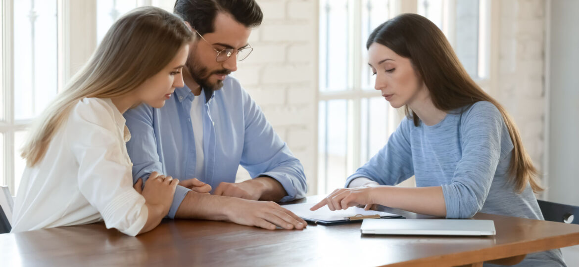 Young woman lawyer explaining agreement details to focused millennial spouses