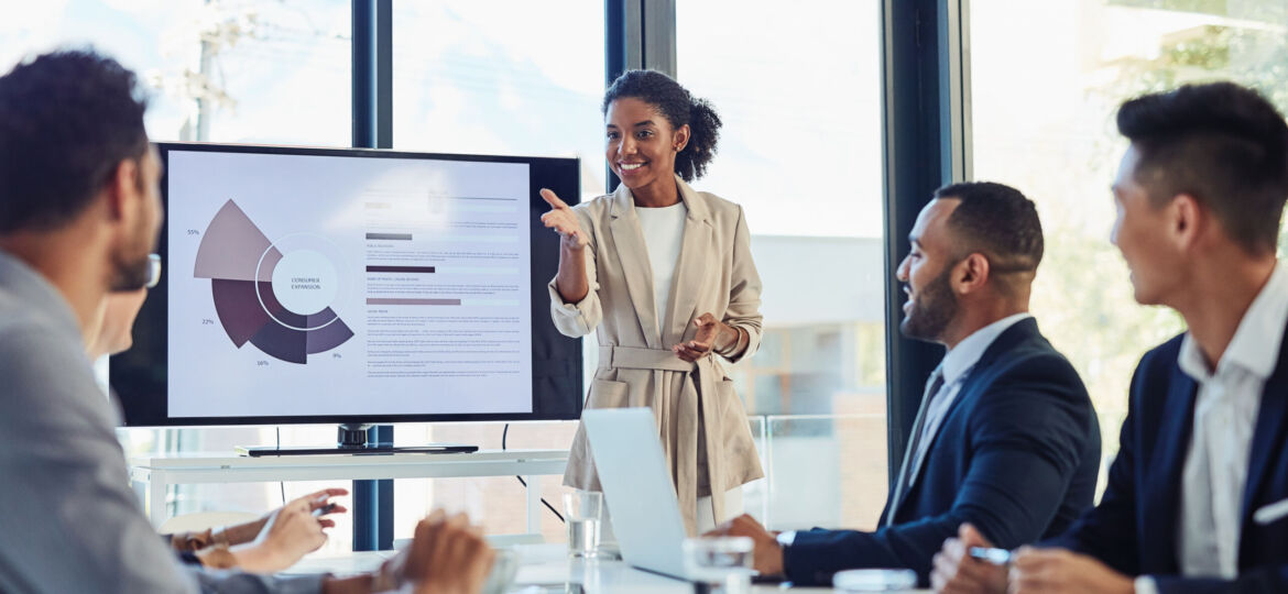 Business meeting, businesswoman and presentation on screen of tv in modern boardroom with colleagues. Workshop, speech and black woman or speaker speaking with coworkers in conference room