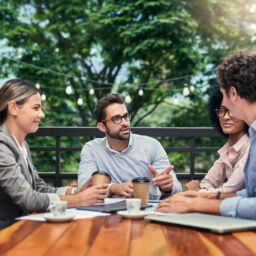 Cropped shot of a group of business colleagues having a meeting outdoors at a cafe.