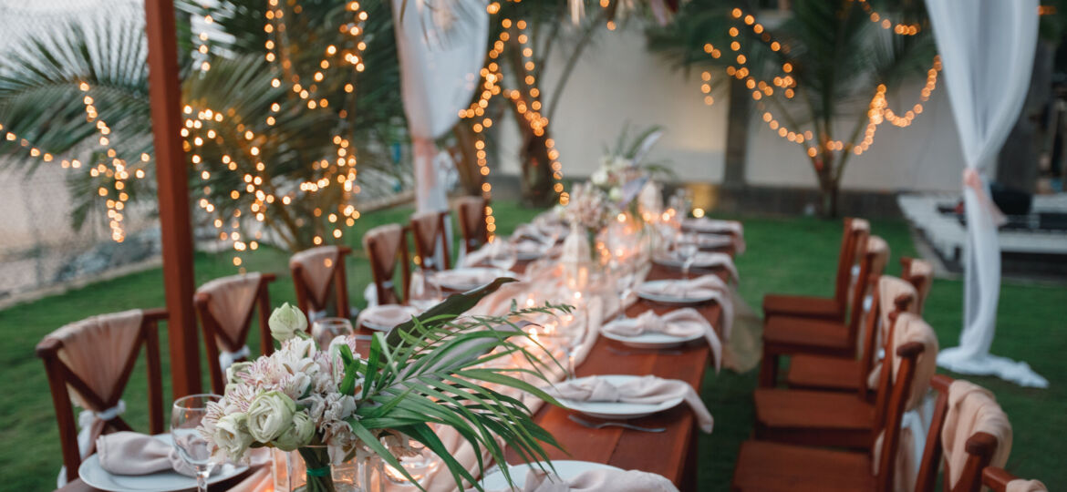 Wedding decoration table in the garden, floral arrangement, In the style vintage & rustic on outdoor. Decorated white table with yellow flowers, served for two people. Fine art laying. Family romantic