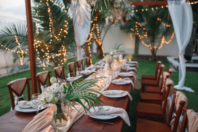 Wedding decoration table in the garden, floral arrangement, In the style vintage & rustic on outdoor. Decorated white table with yellow flowers, served for two people. Fine art laying. Family romantic